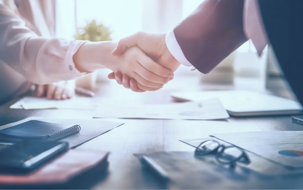 Advisor and client shaking hands over a business meeting